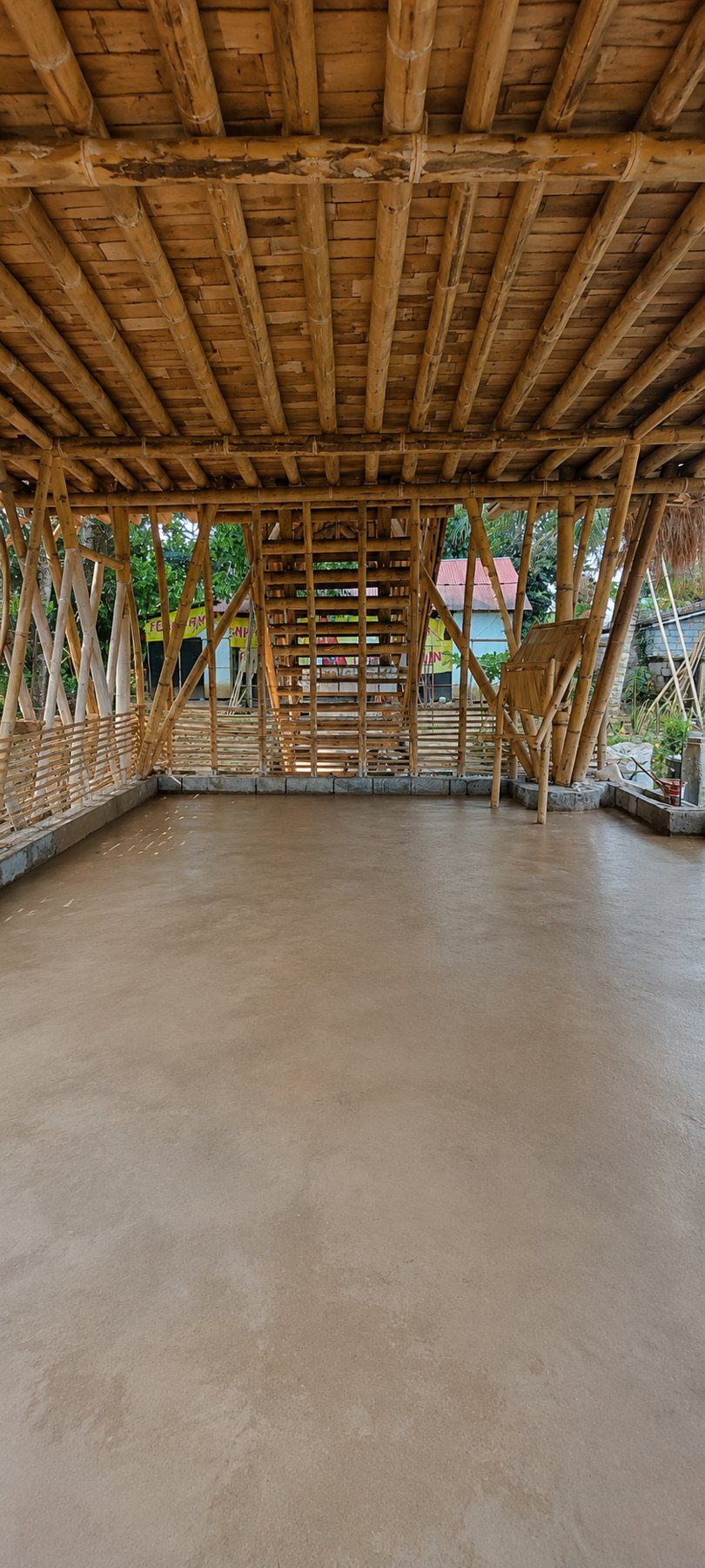 A finished earthen floor inside an open bamboo building at a bamboo building school in Bali